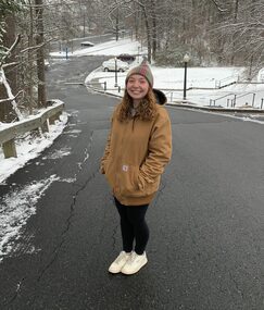 Katy standing on a slope with a snowy background