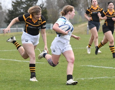 a rugby player in a white uniform running with the ball